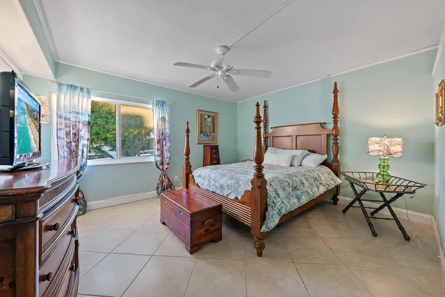 a bedroom with a bed and a flat tv screen on the dresser