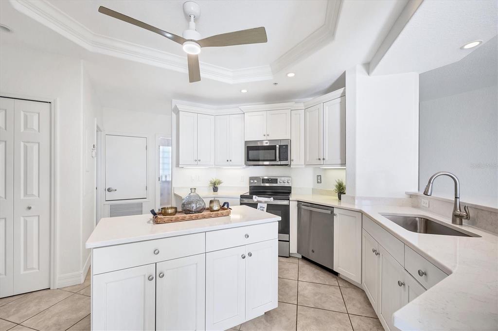 2770 North Beach Road, Unit 303 Englewood, FL 34223 - Photo 13 of 47 a kitchen with white cabinets sink and white appliances