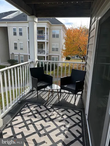 a view of a balcony with chairs and wooden floor
