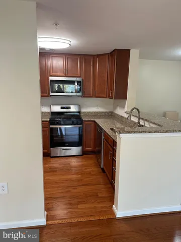 a kitchen with stainless steel appliances granite countertop a sink stove and oven