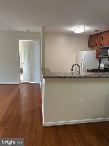 a view of a kitchen with wooden floor and a sink