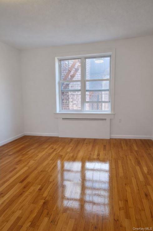 33-16 82nd Street, Unit 6D Queens, NY 11372 - Photo 5 of 16 Empty room with light wood-style flooring
