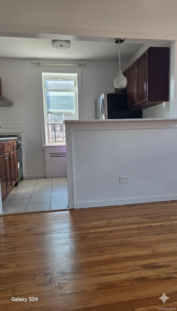 33-16 82nd Street, Unit 6D Queens, NY 11372 - Photo 7 of 16 Kitchen with tasteful backsplash, dark brown cabinets, appliances with stainless steel finishes, and decorative light fixtures