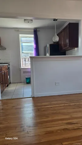 a view of a room with wooden floor and a window