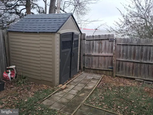 a view of a small house with wooden fence