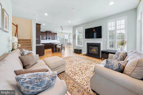 a kitchen with stainless steel appliances wooden floors wooden cabinets dining table and chair