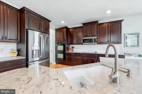 a kitchen with granite countertop a table chairs microwave and cabinets