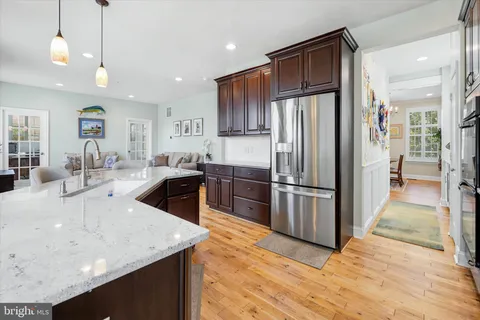 a kitchen with stainless steel appliances granite countertop a refrigerator a sink a stove and oven