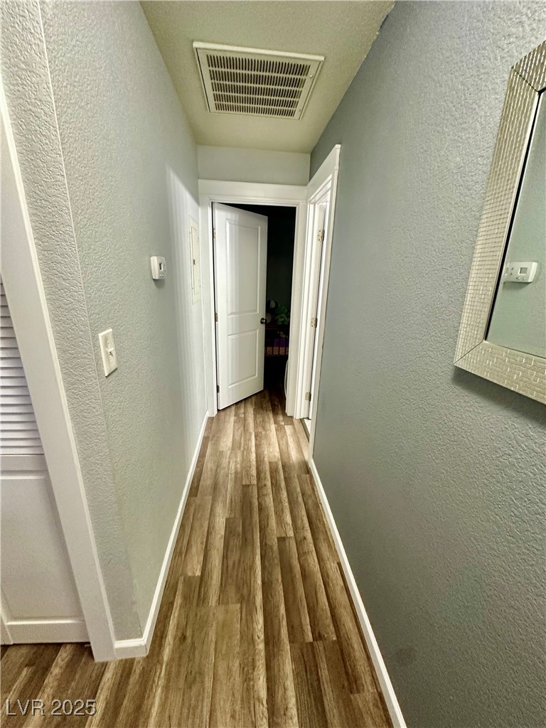 2016 Mesquite Lane, Unit 302 Laughlin, NV 89029 - Photo 17 of 27 Corridor featuring wood finished floors, a textured wall, and baseboards