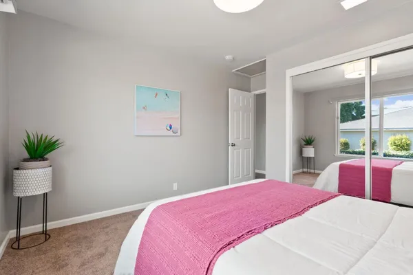 a bedroom with a large bed and a potted plant