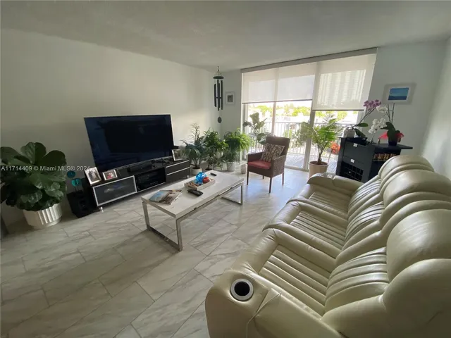 a dining room with wooden floor a chandelier a glass table and chairs