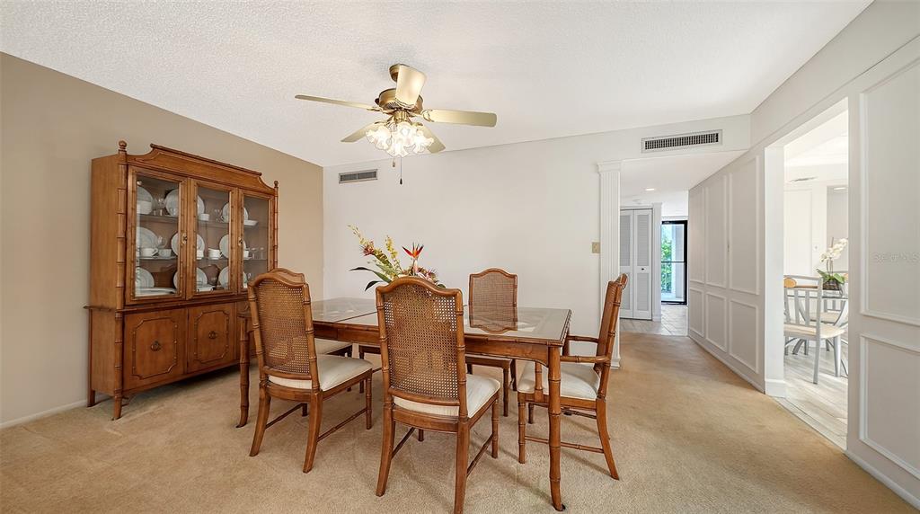 6287 Midnight Pass Road, Unit 103 Sarasota, FL 34242 - Photo 11 of 36 a view of a dining room with furniture and a chandelier fan