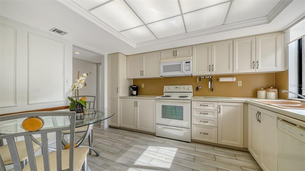 6287 Midnight Pass Road, Unit 103 Sarasota, FL 34242 - Photo 12 of 36 a kitchen with stainless steel appliances granite countertop a sink and cabinets