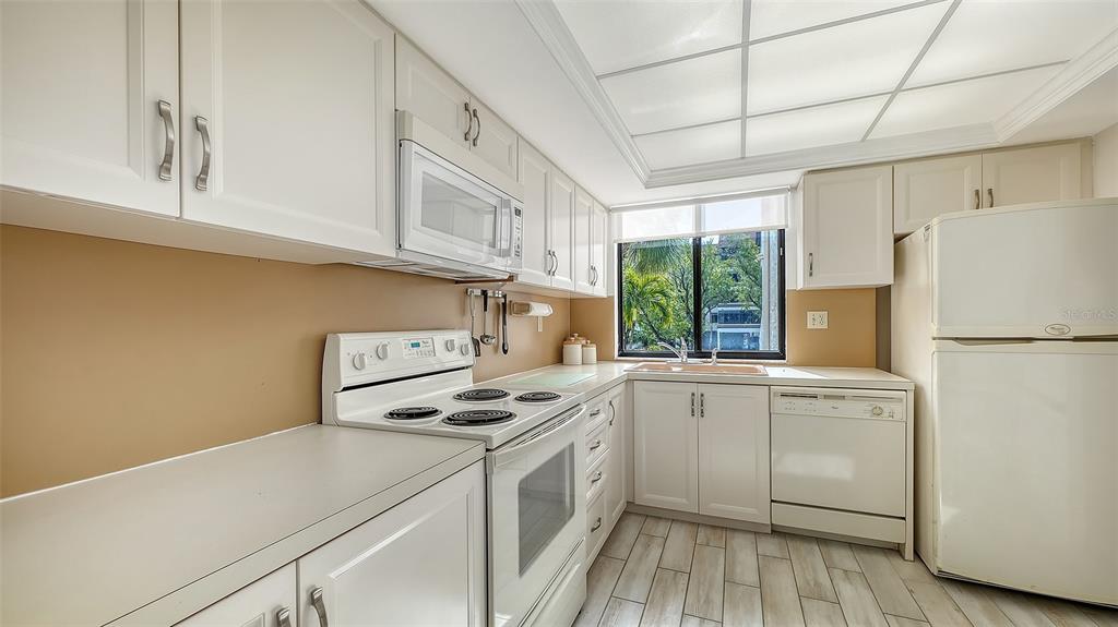 6287 Midnight Pass Road, Unit 103 Sarasota, FL 34242 - Photo 15 of 36 a kitchen with cabinets appliances a sink and a window