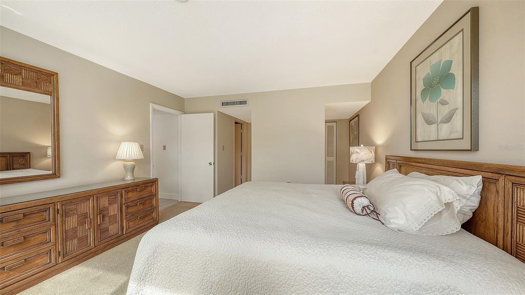 6287 Midnight Pass Road, Unit 103 Sarasota, FL 34242 - Photo 16 of 36 a bedroom with a bed and painting on the wall