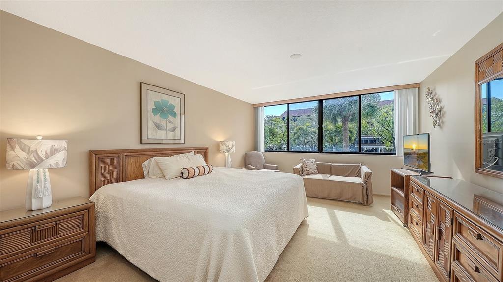 6287 Midnight Pass Road, Unit 103 Sarasota, FL 34242 - Photo 17 of 36 a bedroom with a large bed and a large window