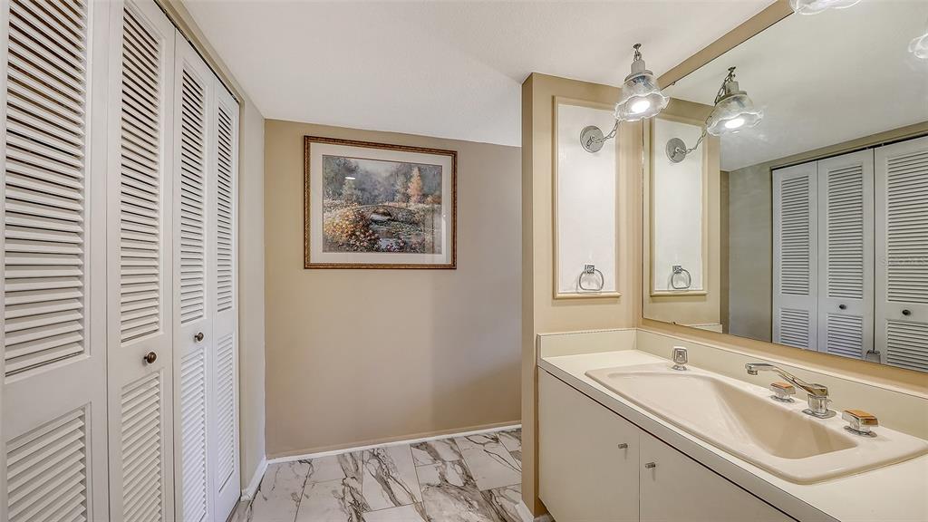 6287 Midnight Pass Road, Unit 103 Sarasota, FL 34242 - Photo 18 of 36 a bathroom with a sink mirror and a shower