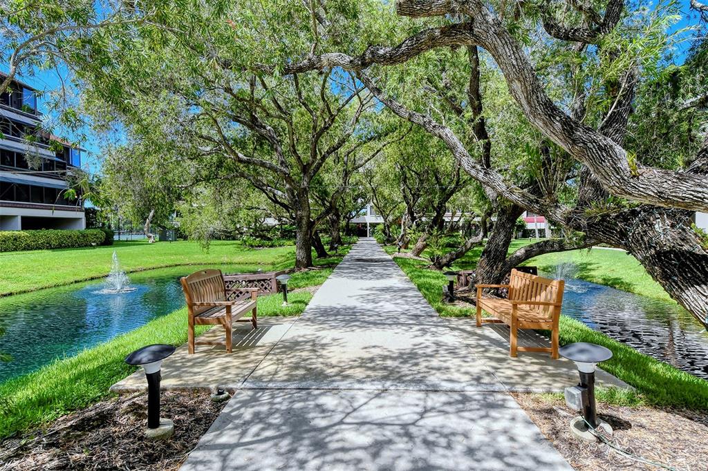 6287 Midnight Pass Road, Unit 103 Sarasota, FL 34242 - Photo 27 of 36 a park view with a bench in garden