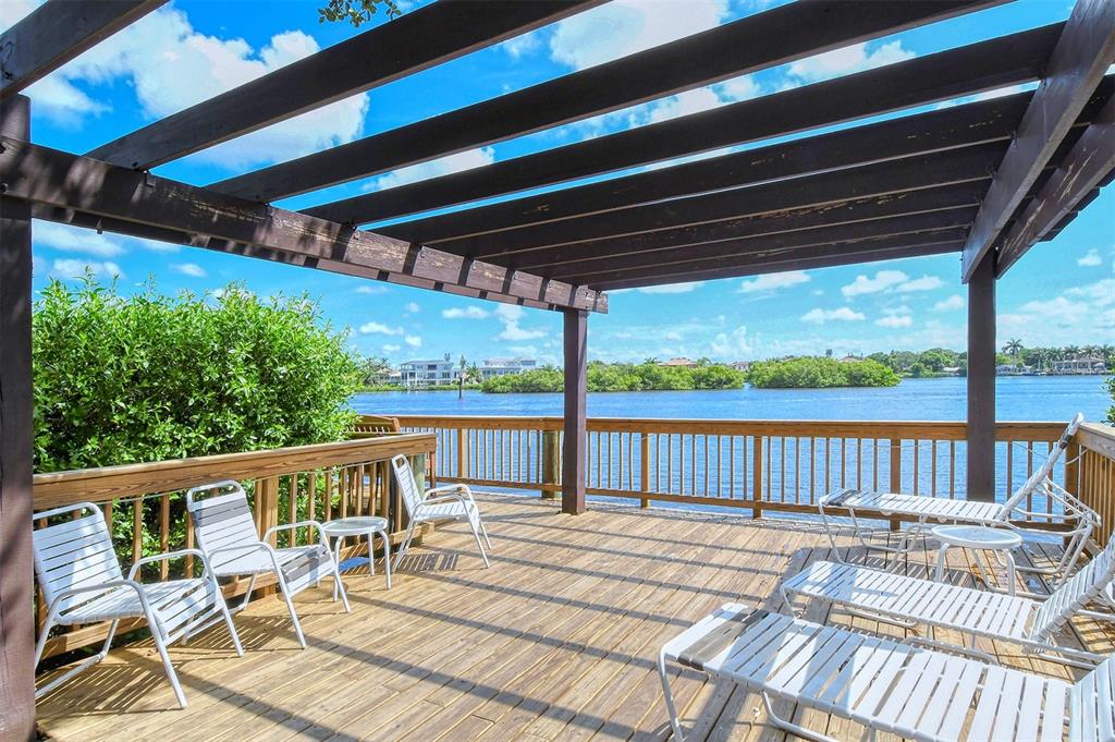 6287 Midnight Pass Road, Unit 103 Sarasota, FL 34242 - Photo 28 of 36 a view of balcony with wooden floor and outdoor seating