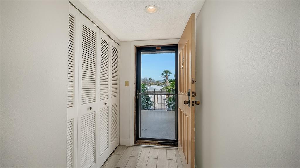 6287 Midnight Pass Road, Unit 103 Sarasota, FL 34242 - Photo 4 of 36 a view of a hallway with wooden floor and a bathroom