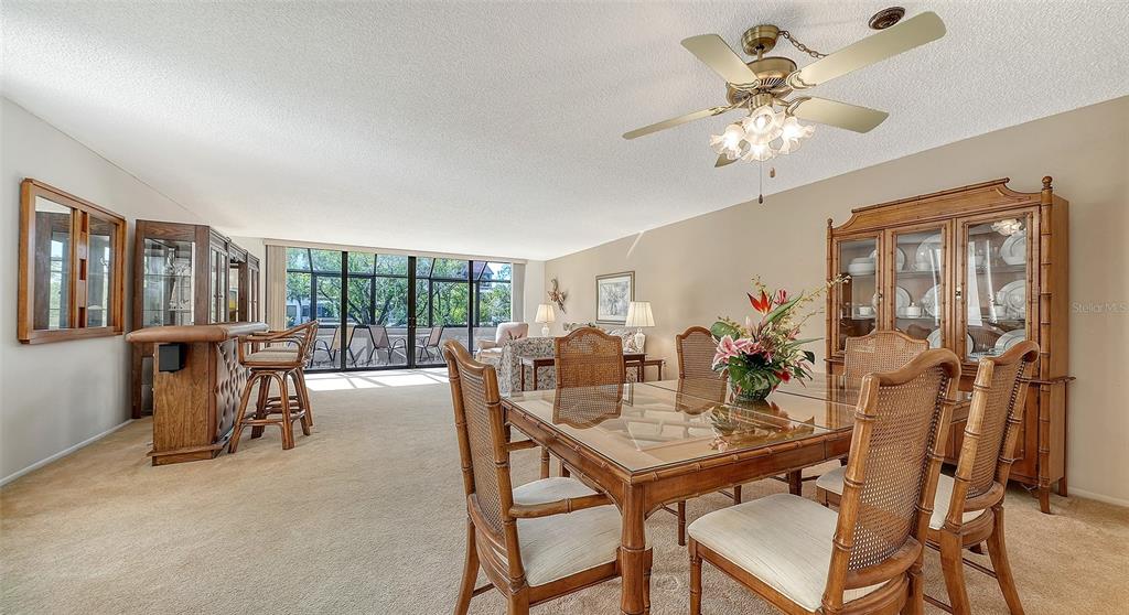 6287 Midnight Pass Road, Unit 103 Sarasota, FL 34242 - Photo 5 of 36 a view of a dining room with furniture a chandelier and wooden floor