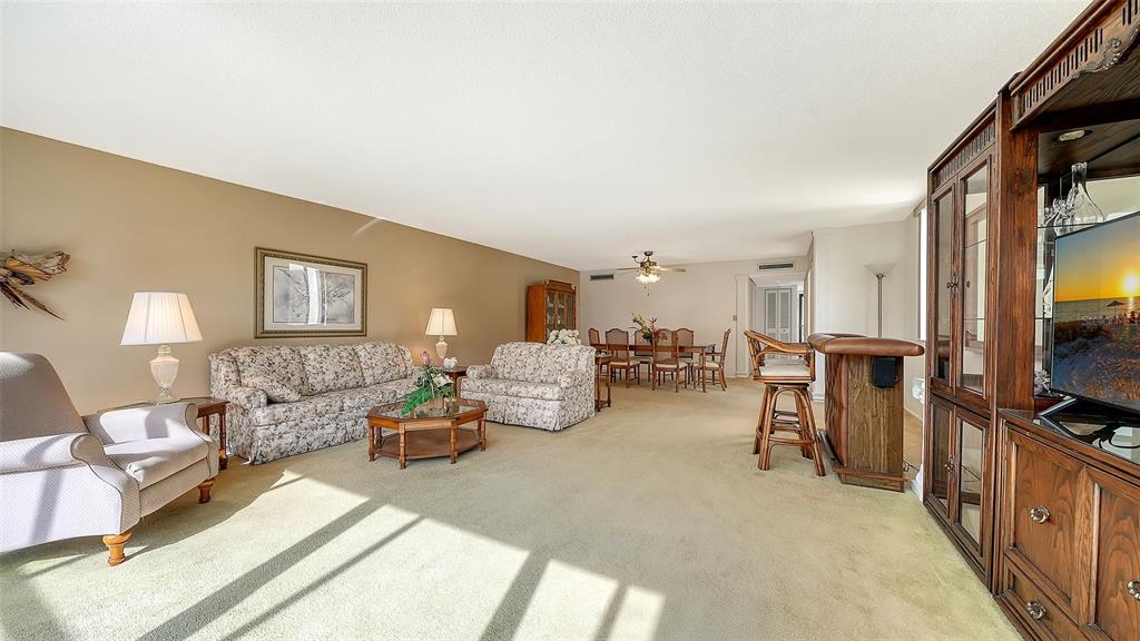 6287 Midnight Pass Road, Unit 103 Sarasota, FL 34242 - Photo 10 of 36 a living room with furniture and a flat screen tv