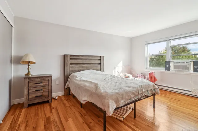 a bedroom with a bed and wooden floor