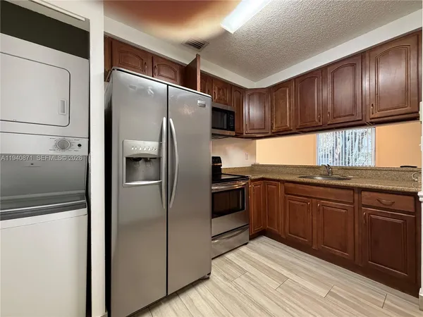 a kitchen with granite countertop stainless steel appliances and wooden cabinets