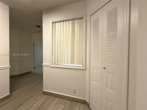an empty room with wooden floor and a window