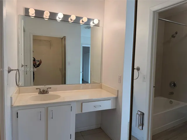 a bathroom with a sink a tub and a mirror