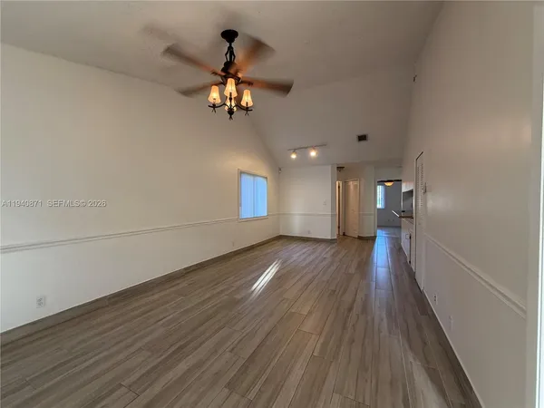 a view of a room with wooden floor and ceiling fan