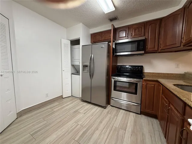 a kitchen with stainless steel appliances and wooden floor