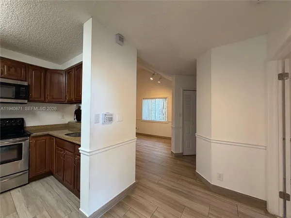 a kitchen with a refrigerator stove and wooden cabinets