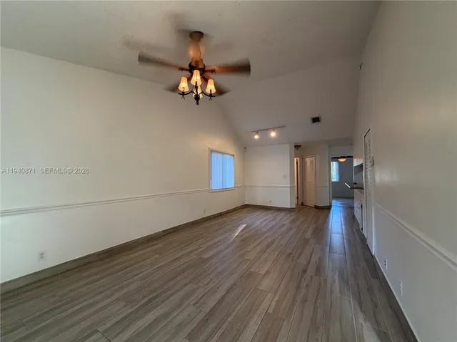a view of a room with wooden floor and ceiling fan