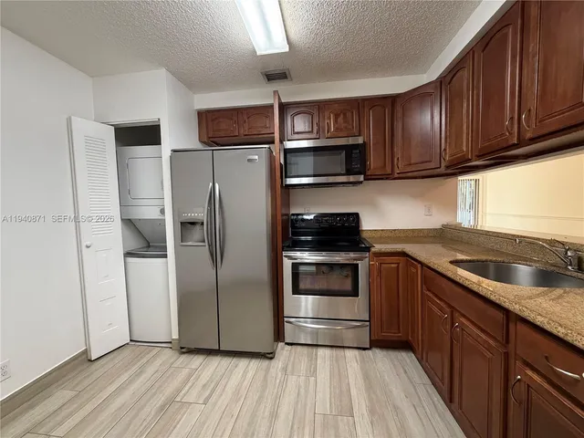 a kitchen with stainless steel appliances granite countertop a refrigerator microwave and sink