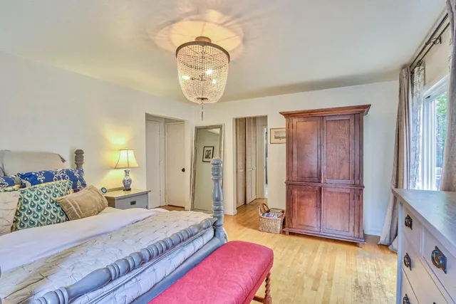 a bedroom with a large bed and a chandelier