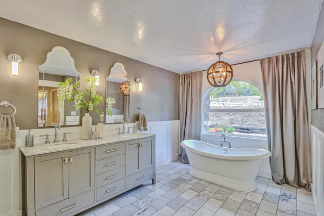 a spacious bathroom with a double vanity sink mirror and a bathtub