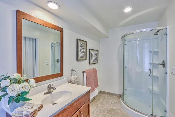a bathroom with a sink mirror and shower