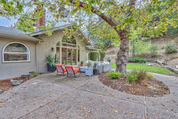 a view of a house with backyard and sitting area