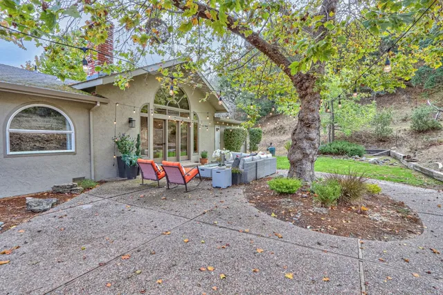 a view of a house with backyard and sitting area