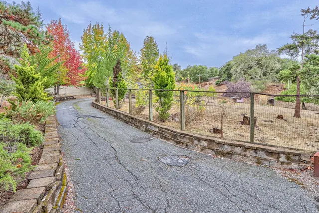 a view of a pathway with a bench in front of house