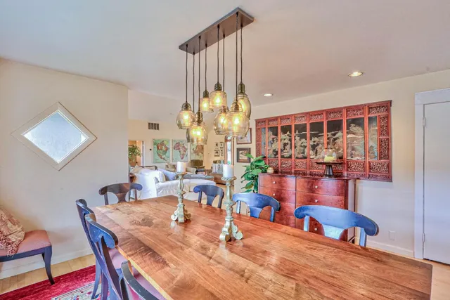a dining room with furniture a chandelier and wooden floor