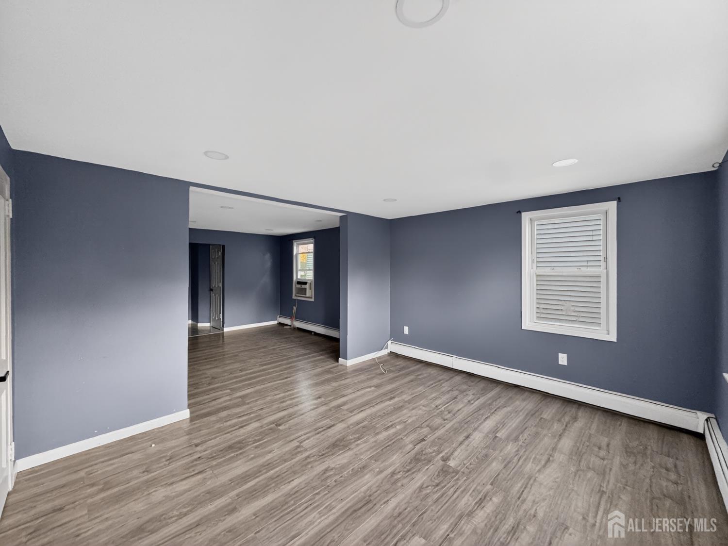 194 High Street, Unit 1 Perth Amboy, NJ 08861 - Photo 2 of 7 a view of an empty room with wooden floor and a window