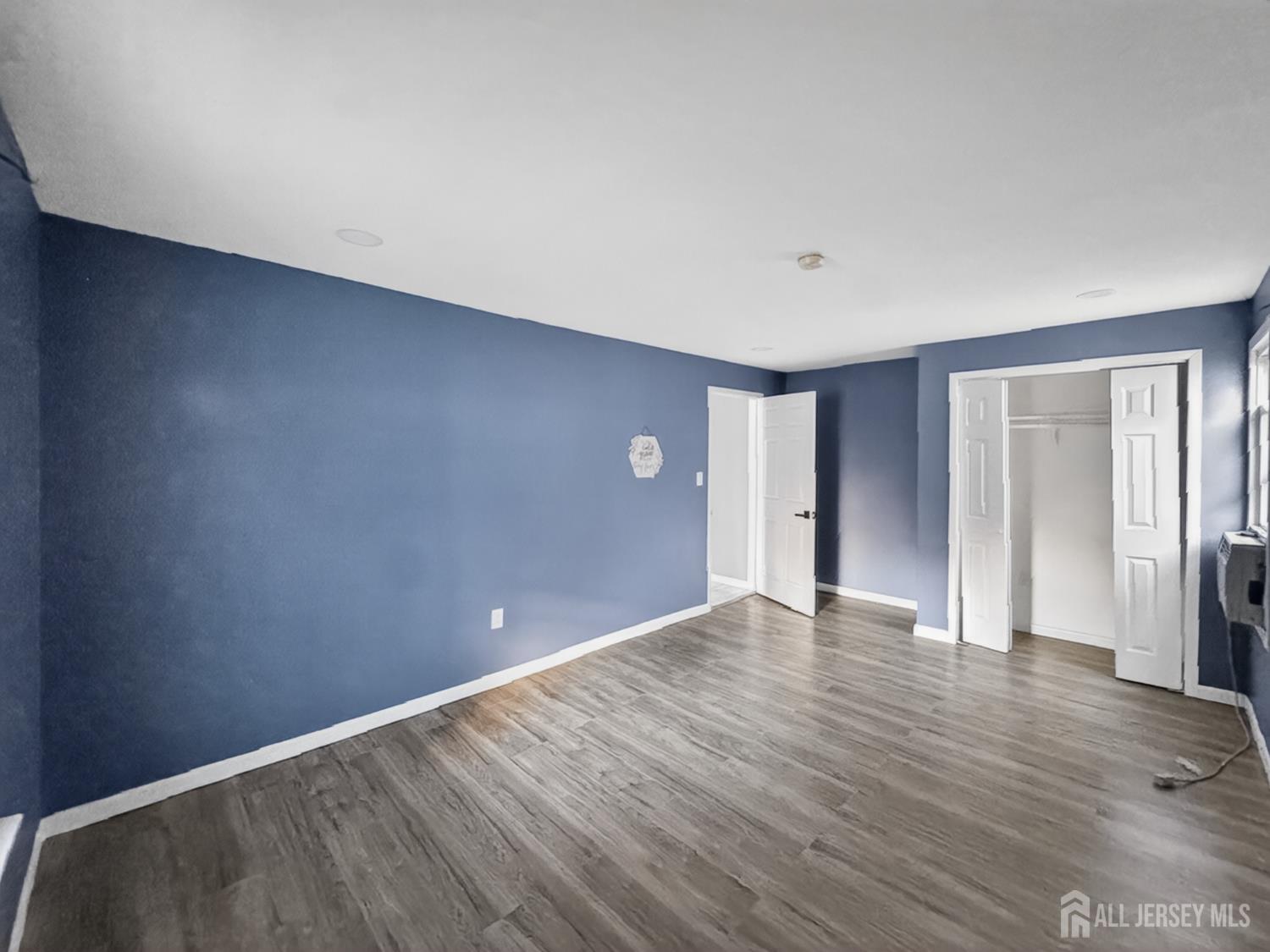 194 High Street, Unit 1 Perth Amboy, NJ 08861 - Photo 5 of 7 a view of an empty room with wooden floor and a window
