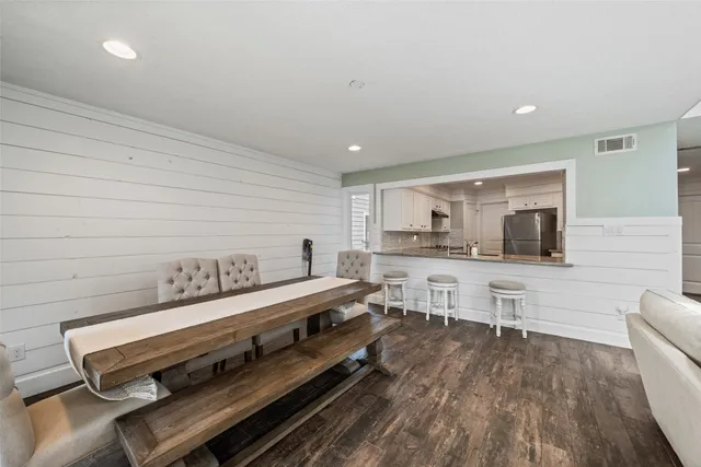 a living room with stainless steel appliances kitchen island granite countertop furniture and a wooden floor