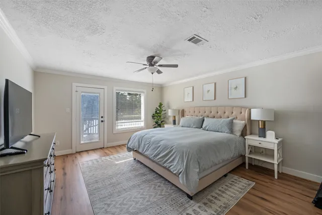 a bedroom with a large bed and a flat tv screen on dresser