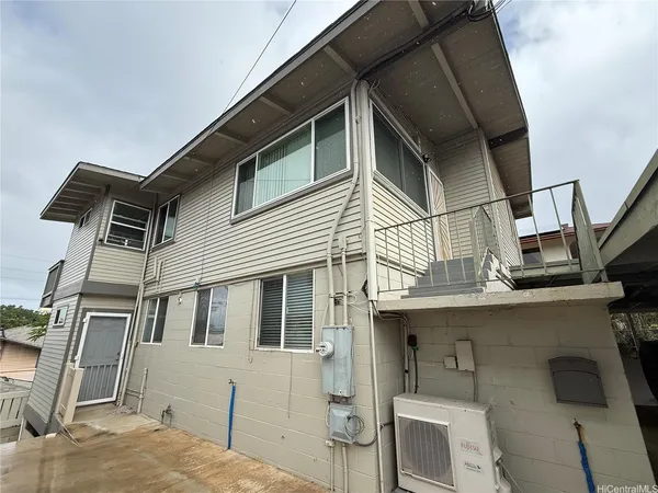 a front view of a house with barbeque grill and seating space