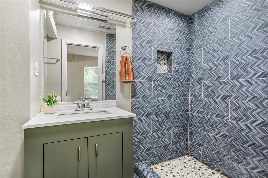 614 Rice Street Denison, TX 75020 - Photo 15 of 22 The tiled shower is an eye-catcher. On the left side that you don't see, there is a shelf for you bathroom supplies and towels.
