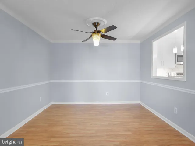 a view of a livingroom with a fireplace a ceiling fan and windows