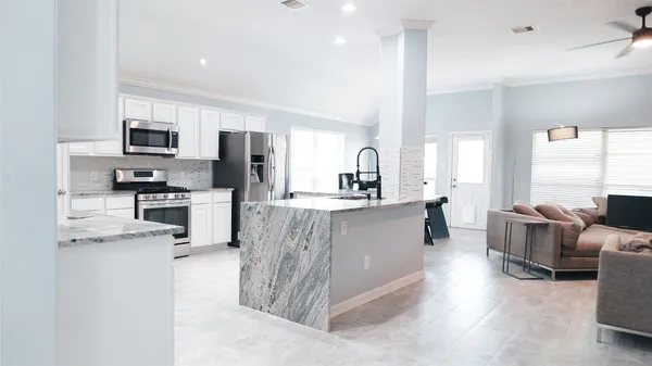 a kitchen with stainless steel appliances kitchen island granite countertop a refrigerator and microwave